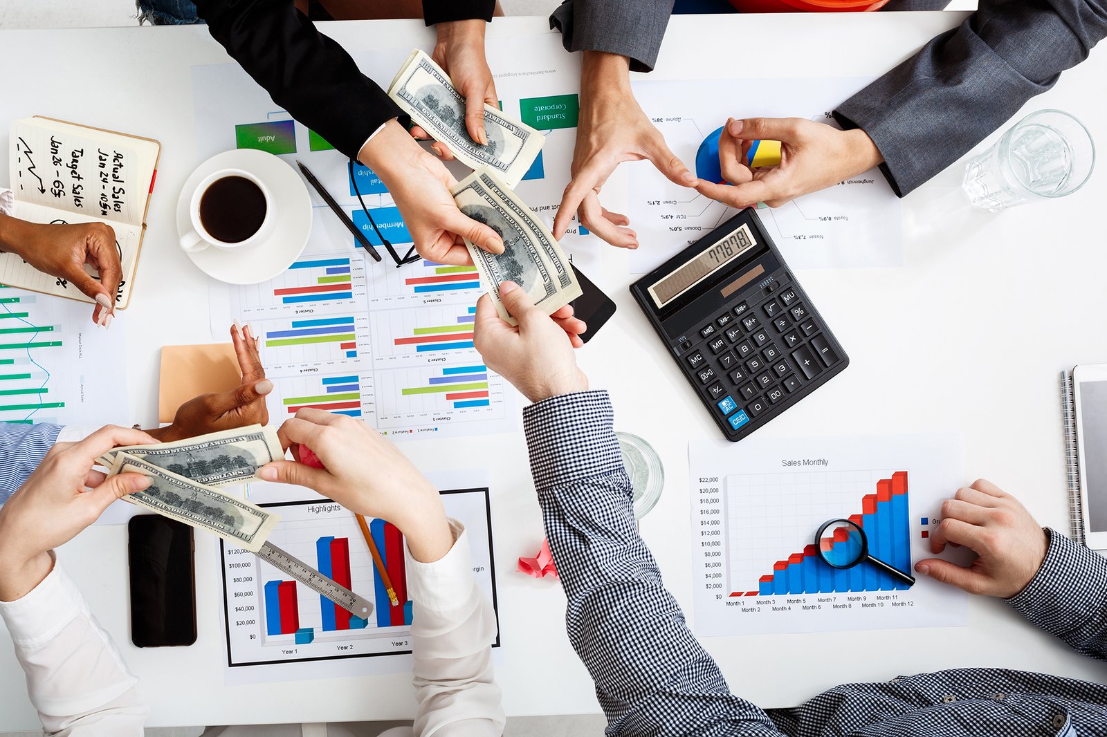 Picture of businessmen’s hands on white table with documents and drafts